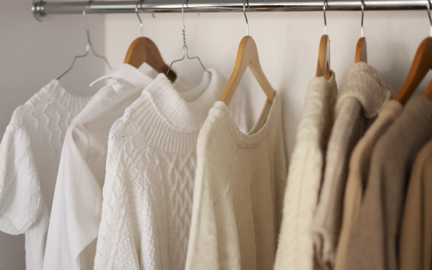 Une collection de vêtements en maille et chemises sur un portant